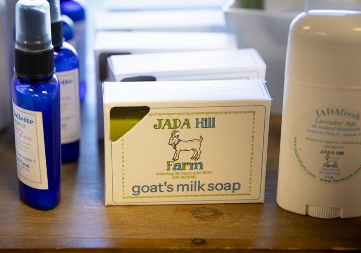 浴室产品，如喷雾在一个蓝色的瓶子和肥皂中的纸盒，显示在一张木桌上