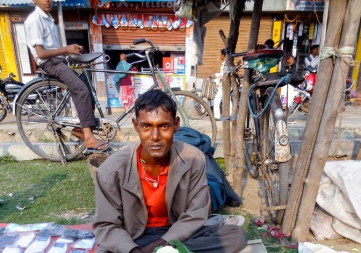 一个人在印度卖花椰菜和西红柿在印度的一个室外市场。