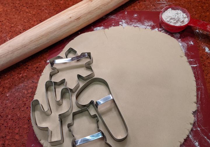 擀面杖，面粉，饼干面团和饼干切割机坐在桌子上