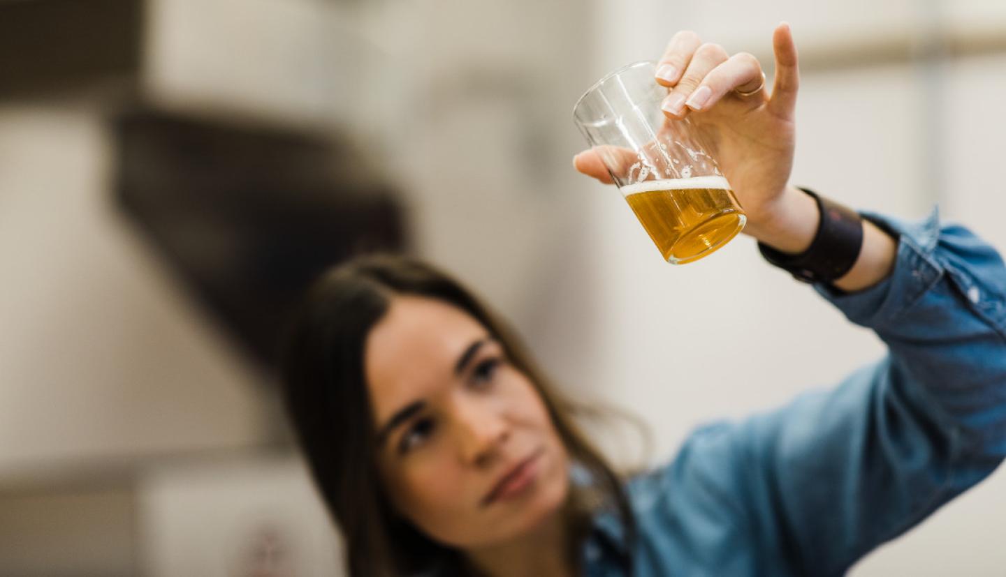 一个女人看着一杯啤酒